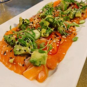 Chef Rocio Fleckenstein serves a salmon crudo with a twist of lime, drizzled with white truffle oil and topped with green onions, avocado and Serrano chilies.