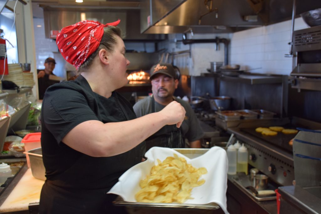 Executive Chef Kat Johnson salts freshly fried chips in the kitchen of Luce Bar & Kitchen on April 26, 2019. 